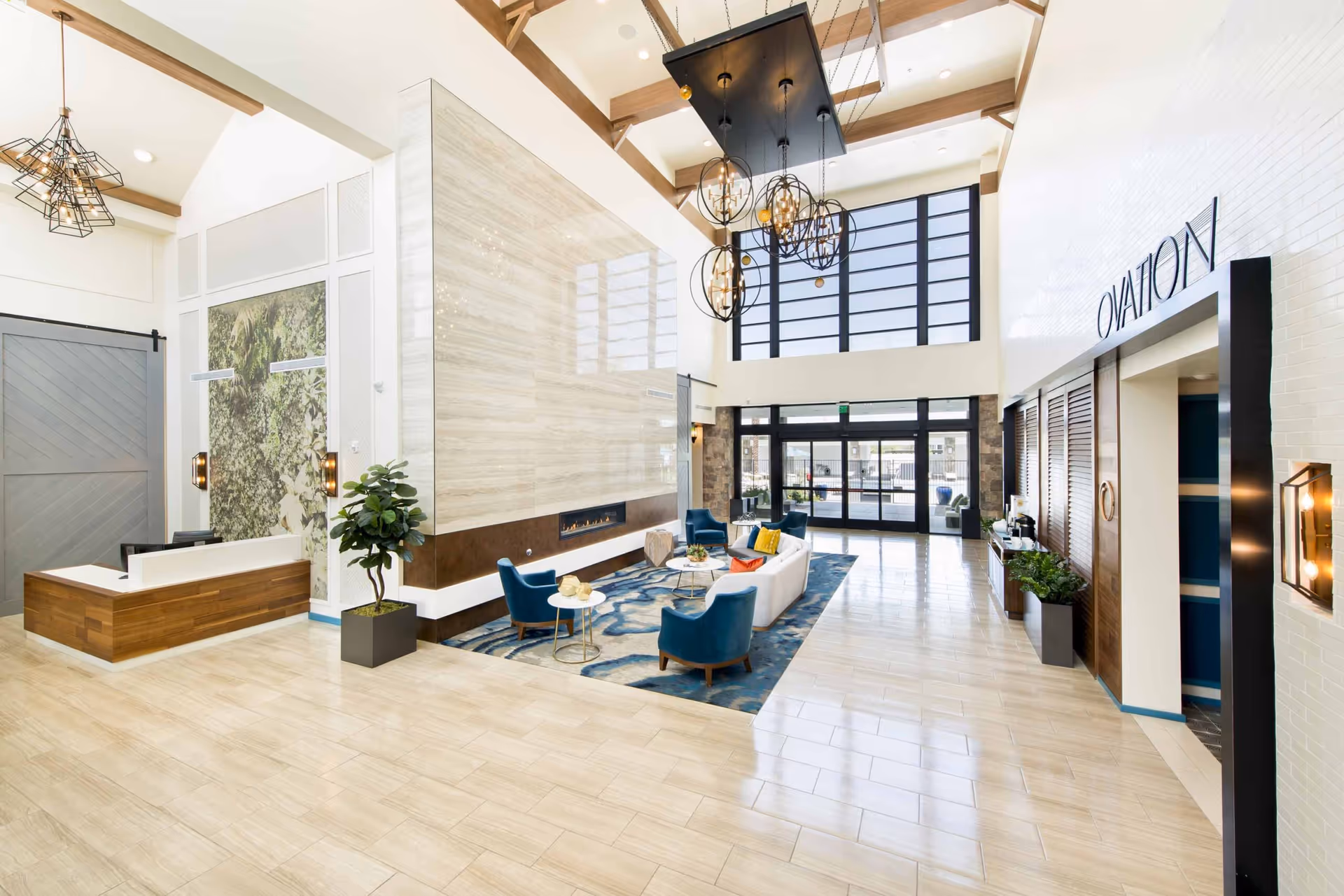 Bright, modern hotel-style lobby with reception desk, seating area, and glass entrance.