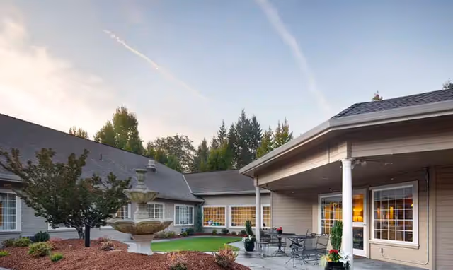 Exterior courtyard at Martin House featuring a fountain, patio seating, and warm-lit windows.