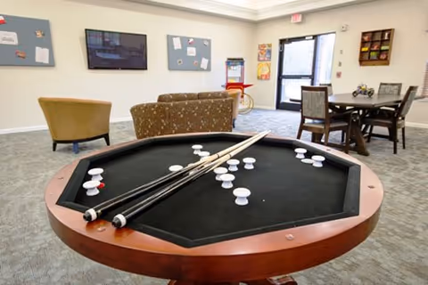 Indoor common area with a billiards table, couches, and a dining nook.