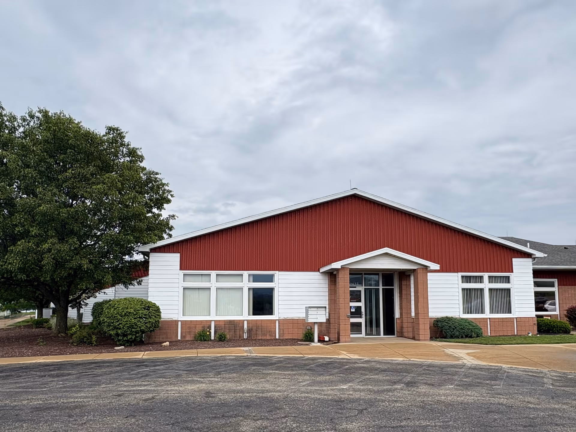 Exterior view of BAYADA Habilitation facility with a red gabled roof and white facade.