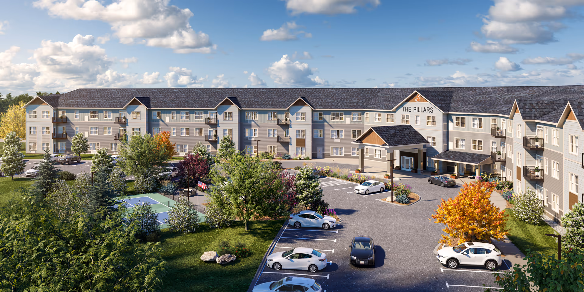Exterior view of The Pillars of Hermantown senior living building with cars and landscaping.