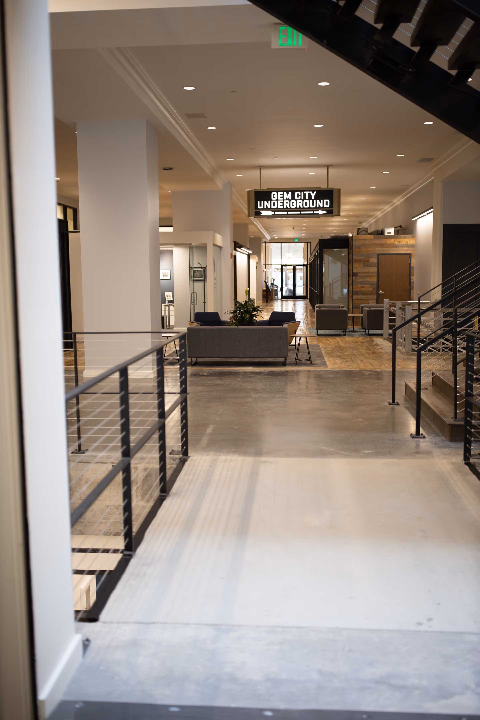 Long bright interior hallway of a senior living facility with a seating area.