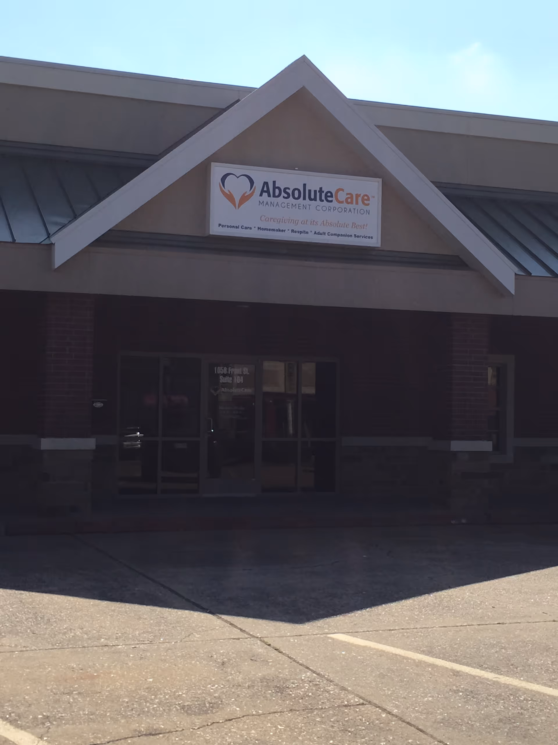 Exterior view of Absolute Care building with entrance and sign above doors.