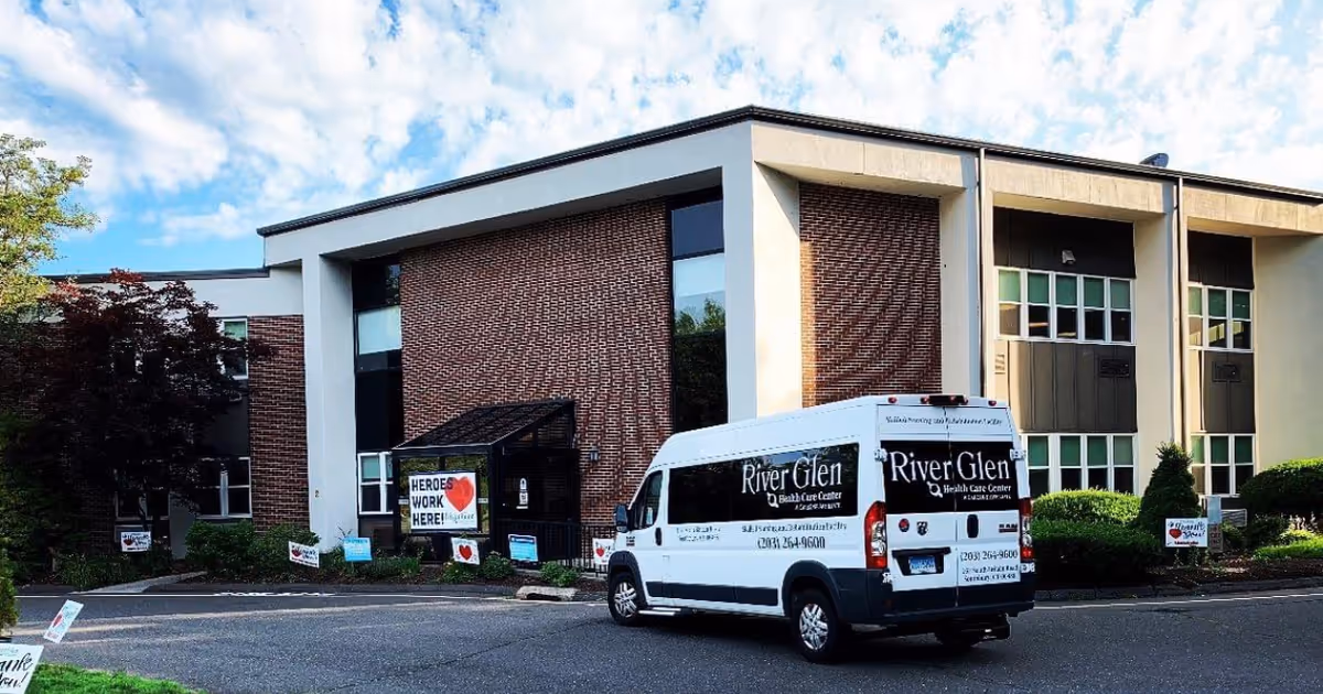 Exterior view of River Glen Health Care Center building with a white service van.