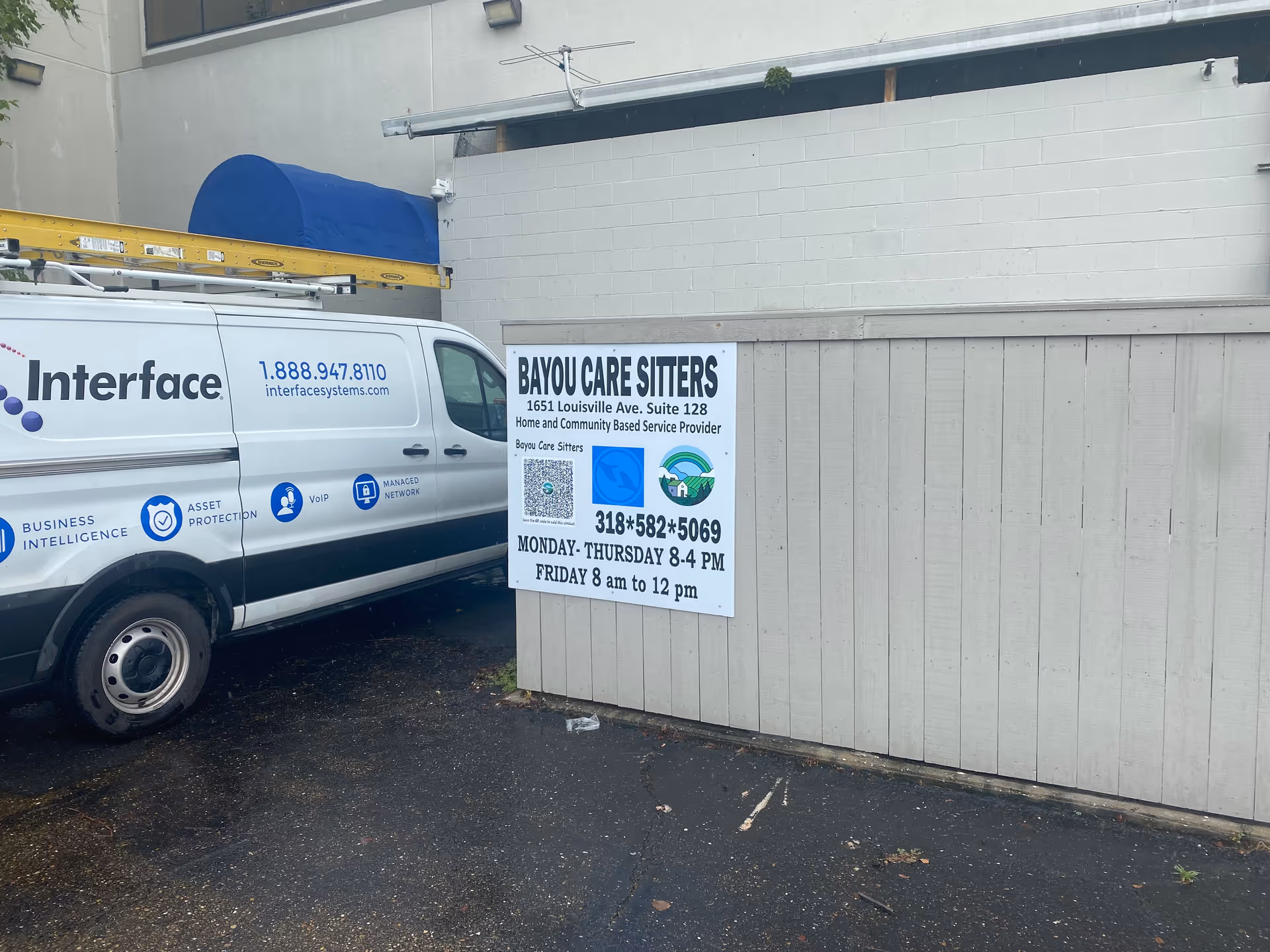 Exterior view shows Bayou Care Sitters signage on a wall beside a company van.