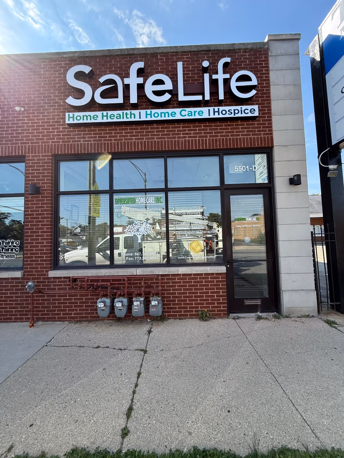 Red brick storefront with large Safe Life sign, glass windows, and a door.
