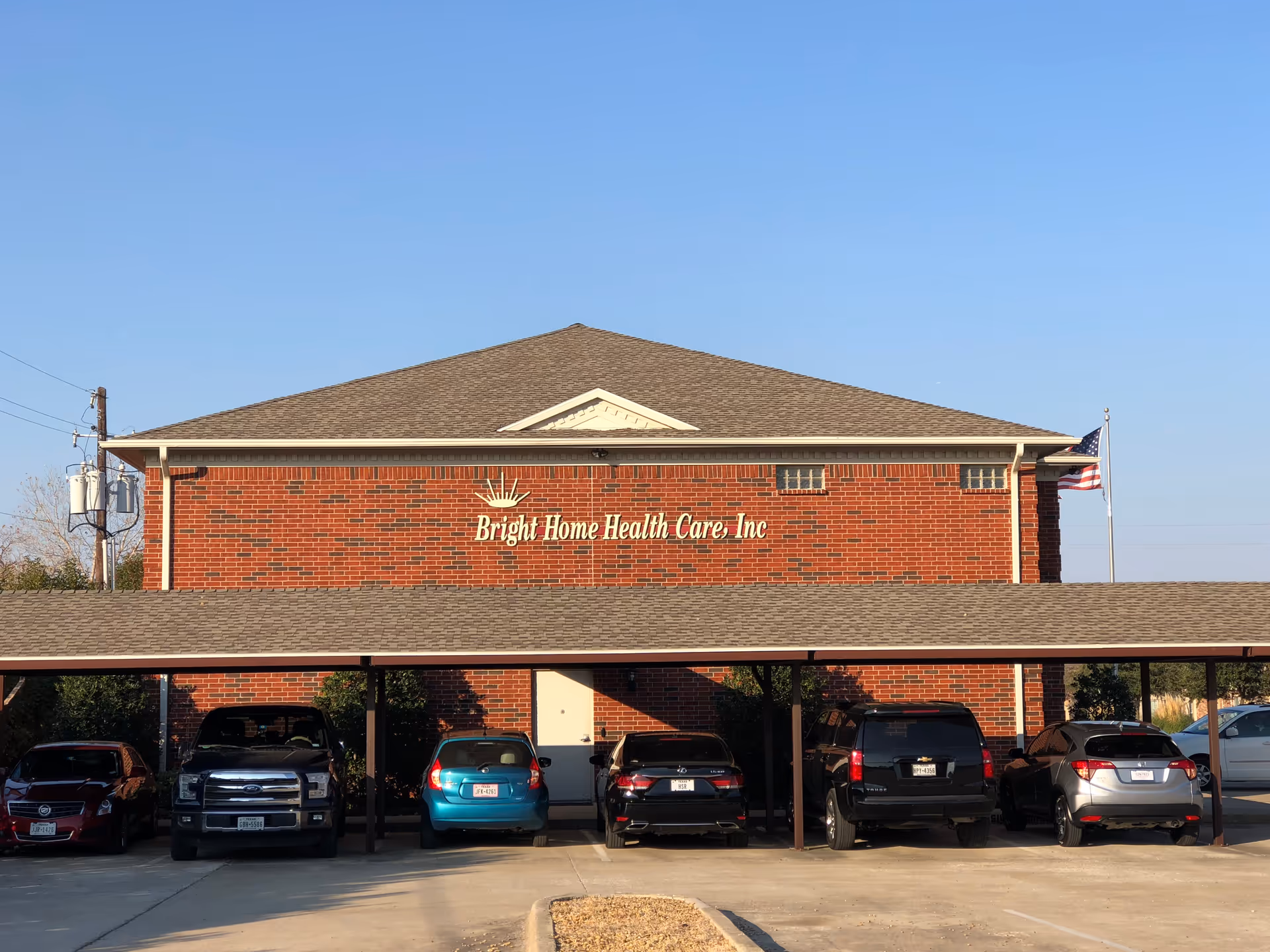 Brick building with Bright Home Health Care, Inc sign and a row of parked cars.