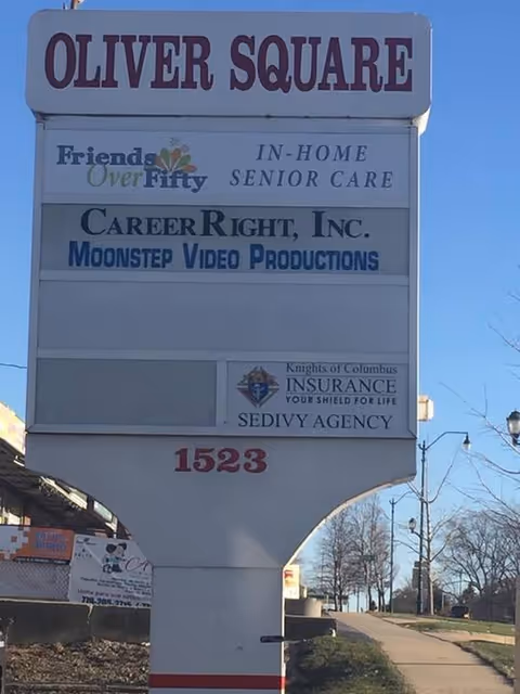 Outdoor signboard at Oliver Square featuring Friends Over Fifty Senior Care and tenants.