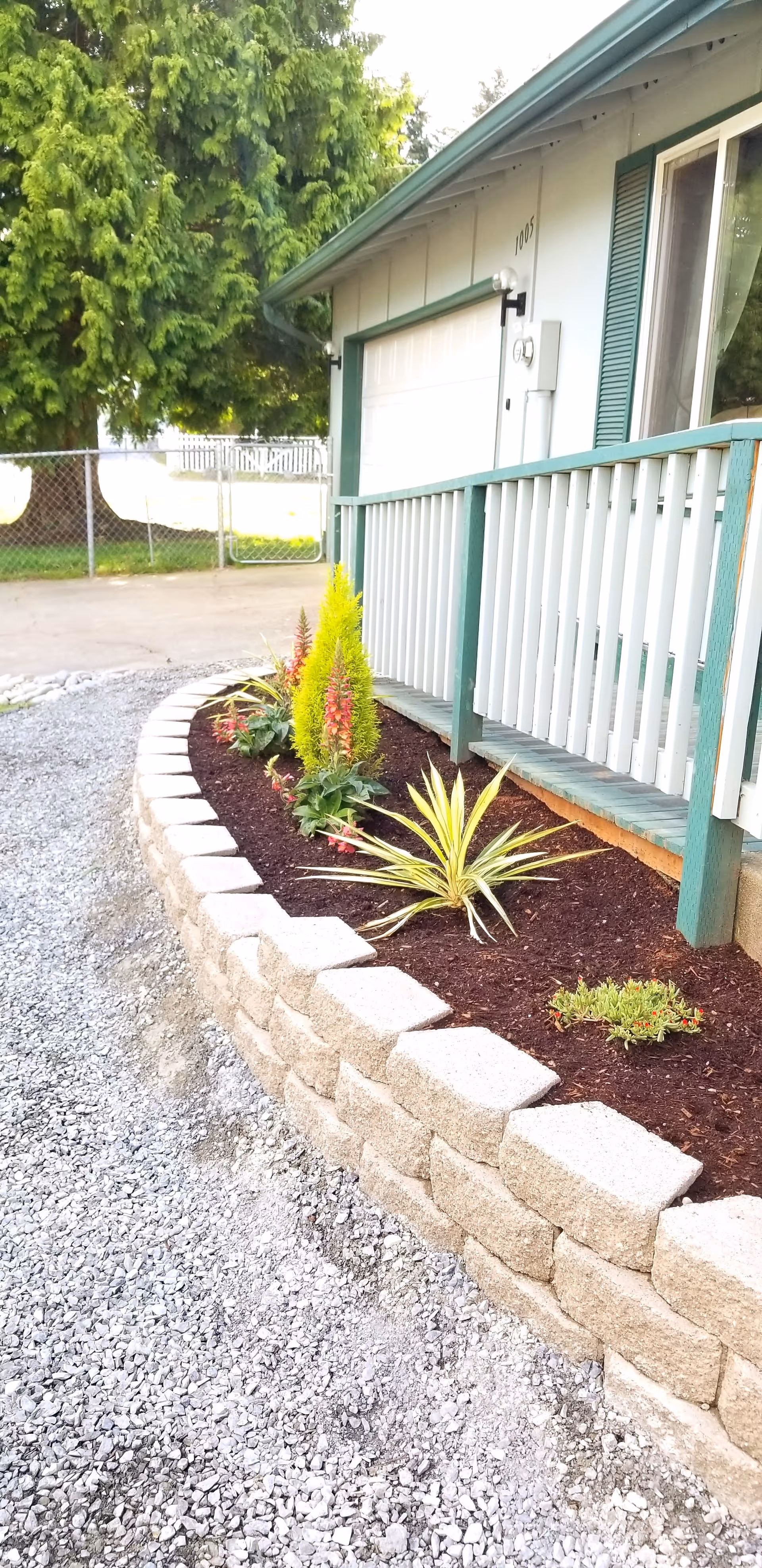 Exterior view of a small senior home with a raised garden bed along the front walkway