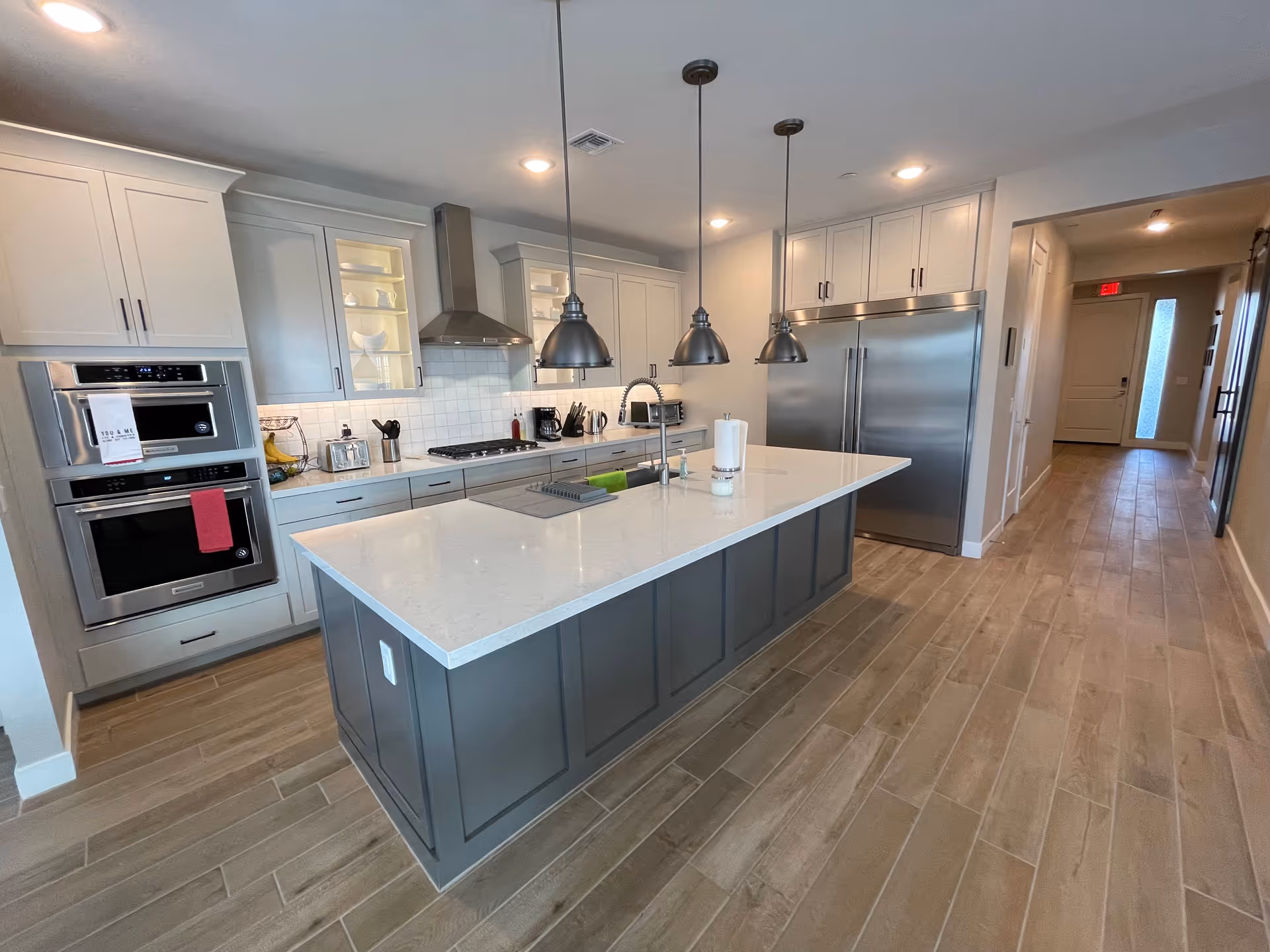 Modern kitchen with island, stainless appliances, and light gray cabinetry in AZ Assisted Living.