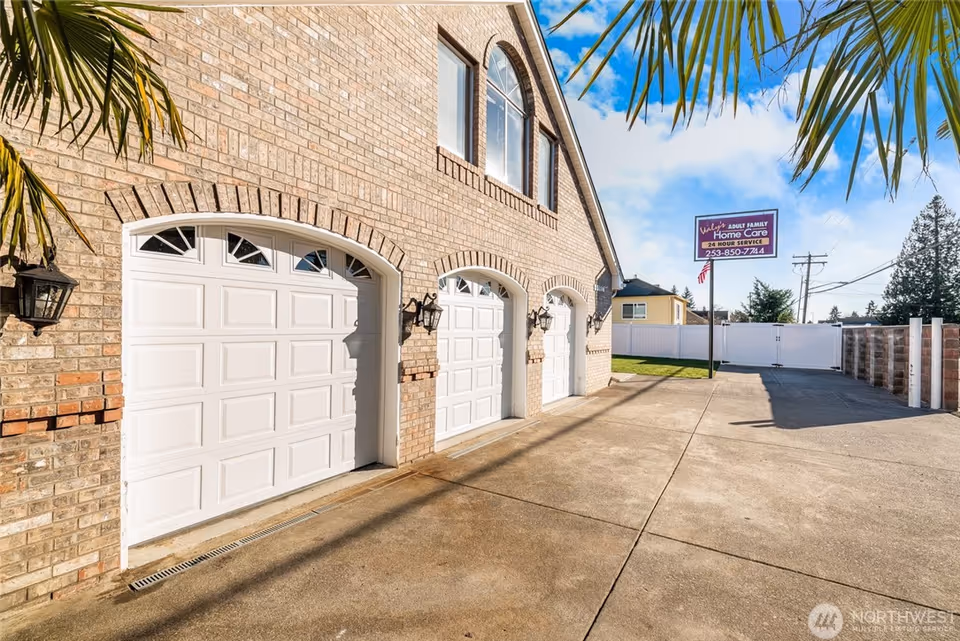 Brick building with white garage doors and a sign for Valy's Adult Family Home.