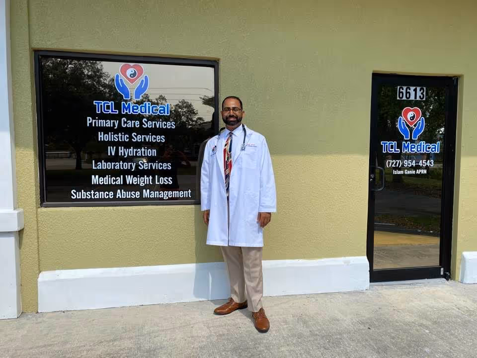 A man in a white lab coat stands outside the TCL Medical building entrance.