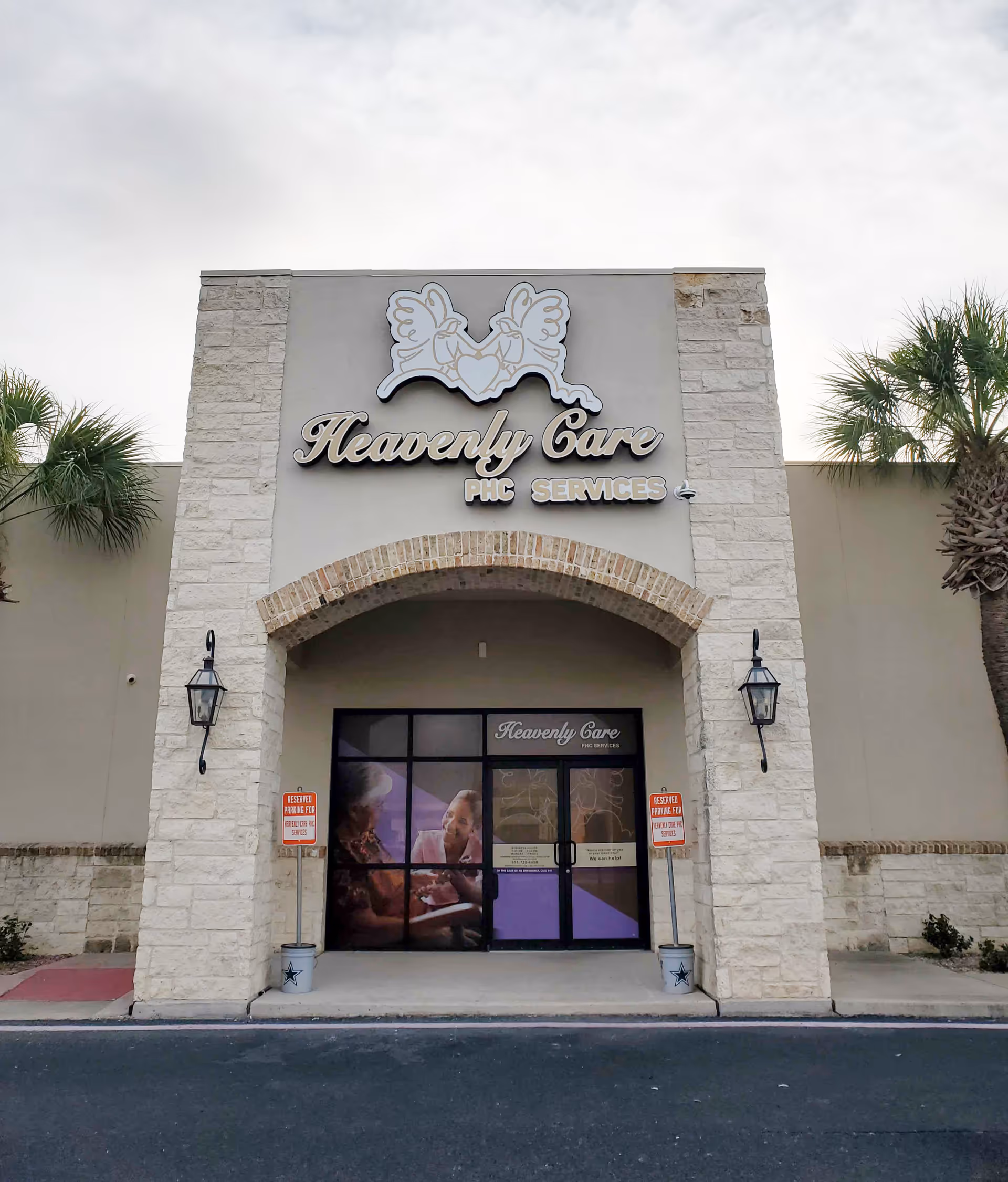 Front entrance of Heavenly Care PHC Services facility with stone arch and palm trees.