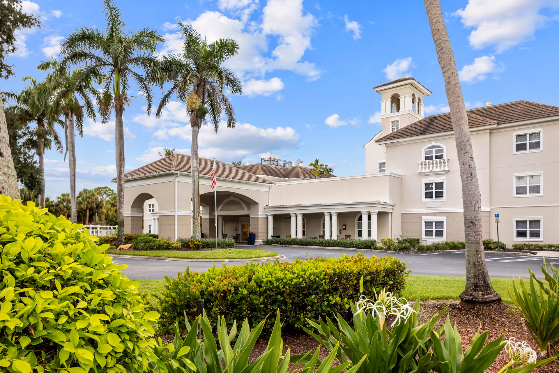 Exterior view of Brookdale Bonita Springs facility with palm trees and landscaping.