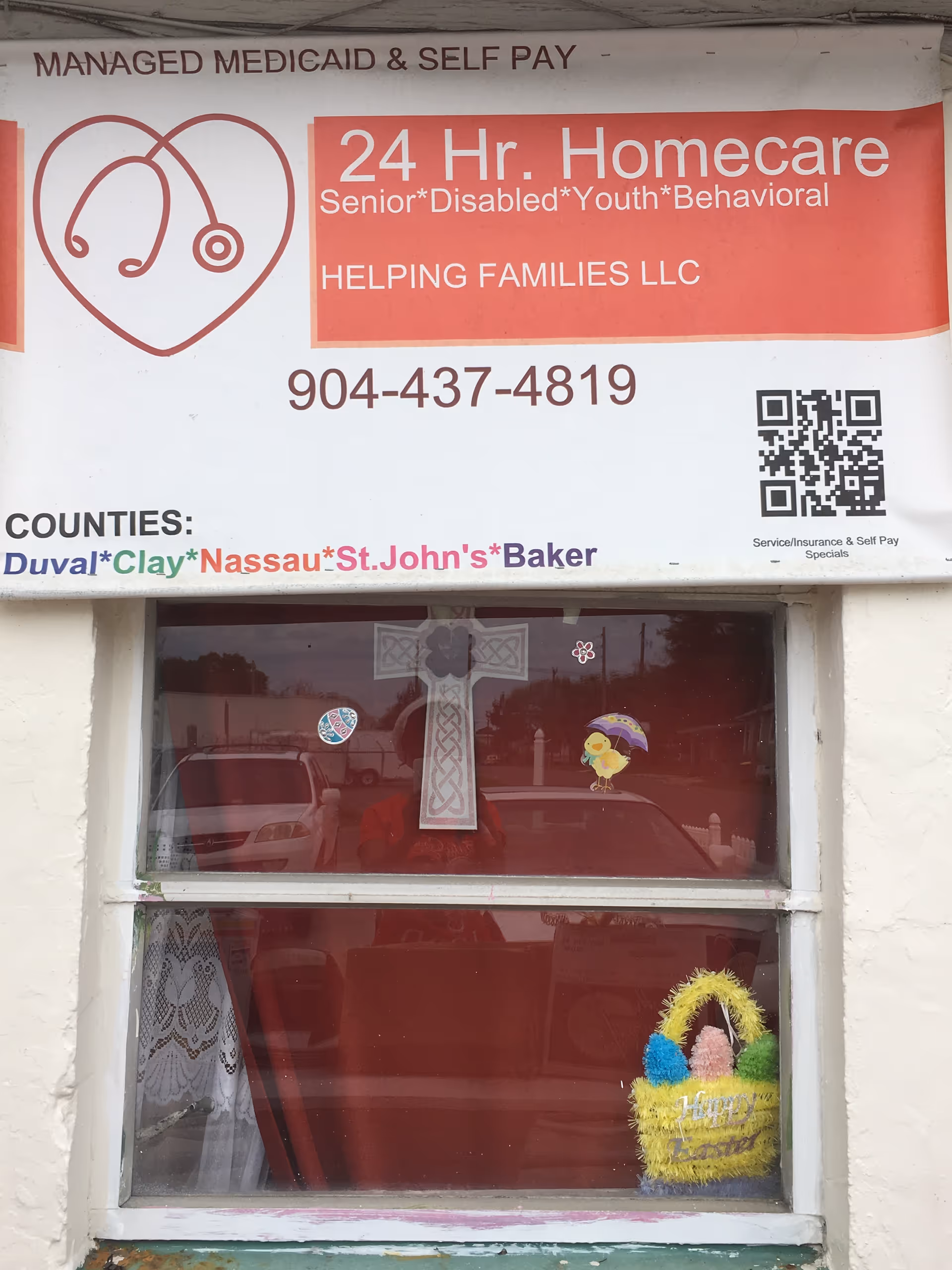 Front of building with Helping Families LLC sign and decorated window