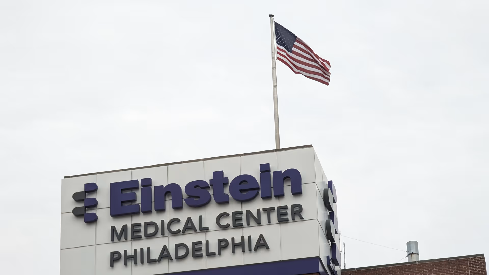 Einstein Medical Center Philadelphia sign on a building exterior with an American flag.
