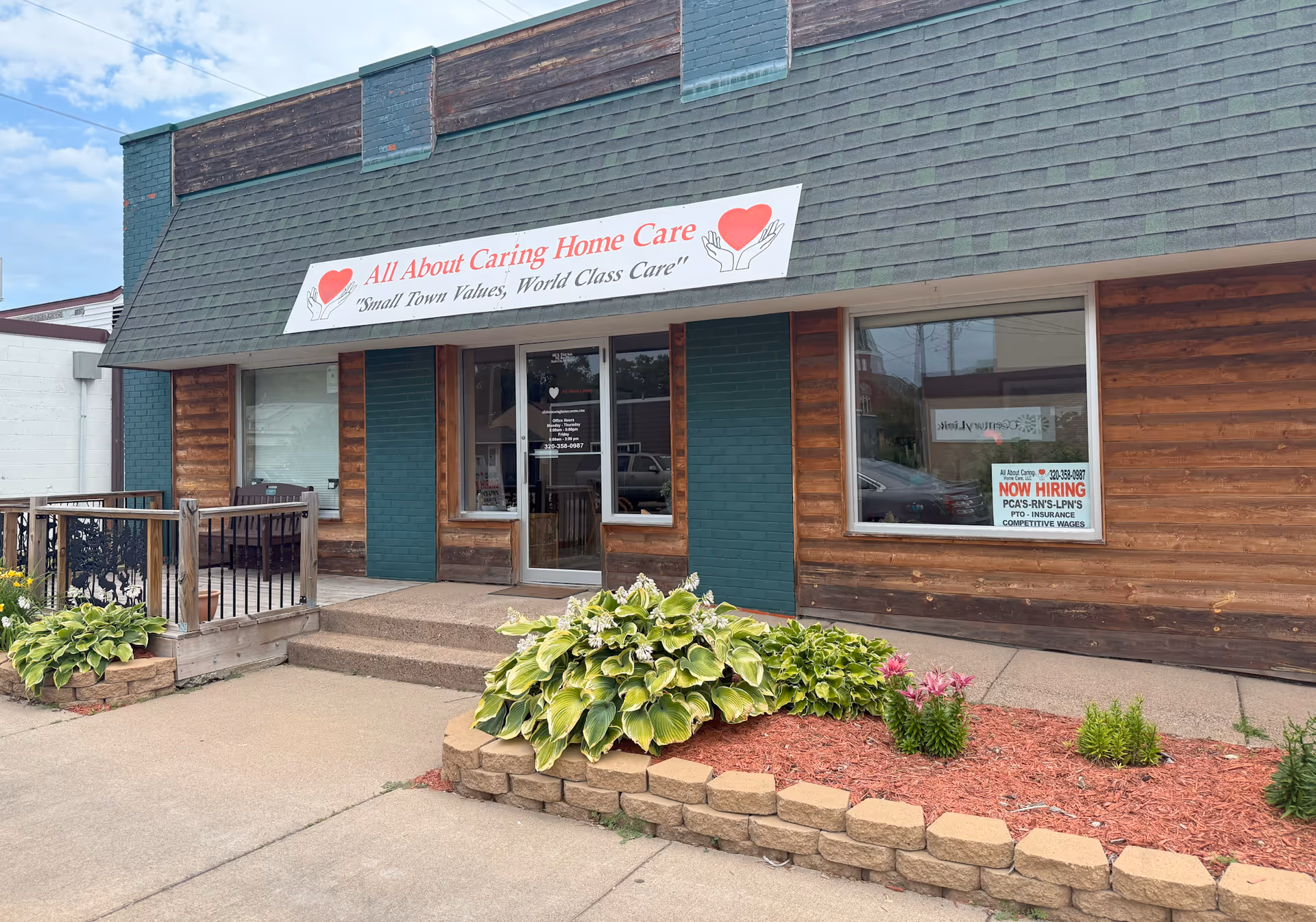 Exterior view of All About Caring Home Care storefront with wooden siding and landscaping