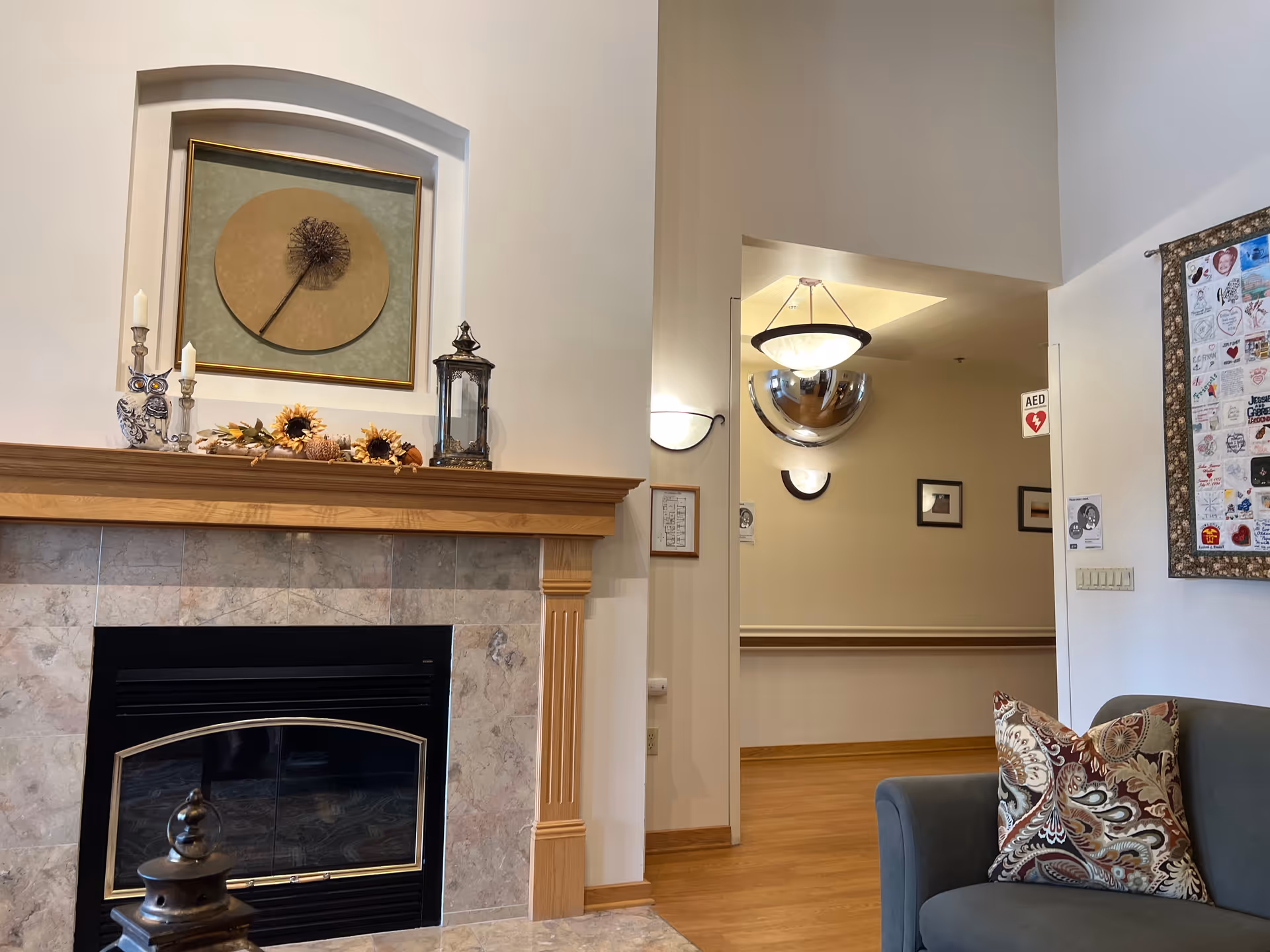 Cozy living room in Hospice Alliance featuring a marble fireplace, mantle decor, and a sofa.