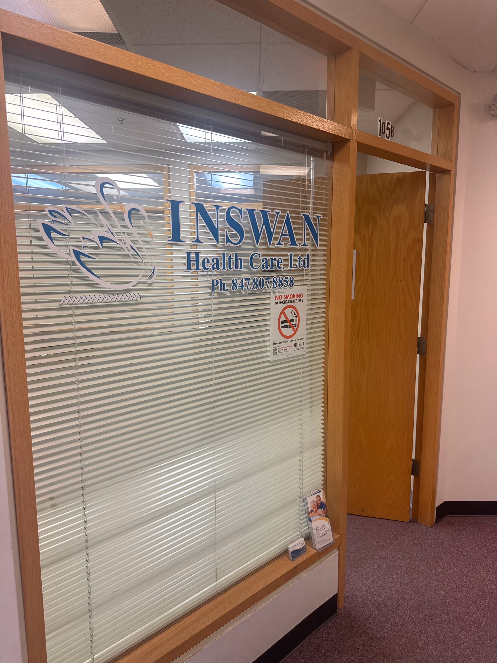 Interior hallway with glass partition displaying Inswan Health Care Ltd logo and doorway.