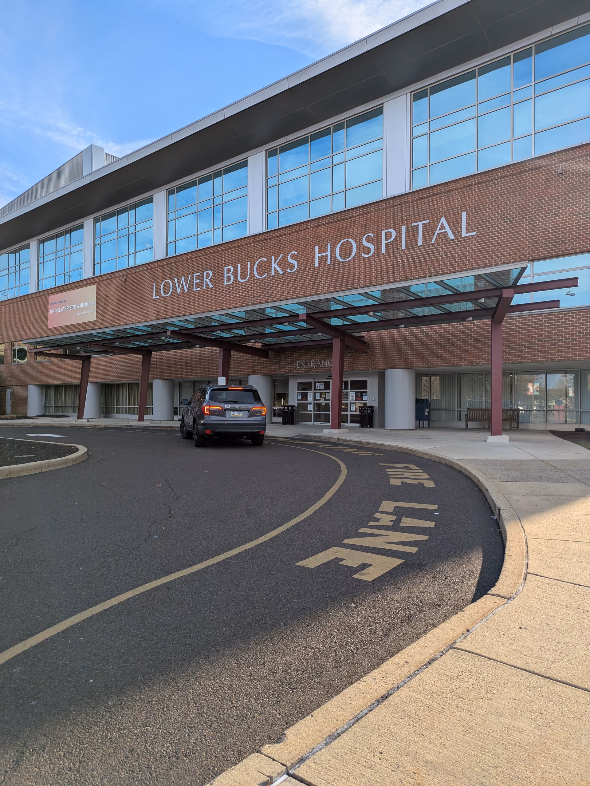 Exterior view of Lower Bucks Hospital with entrance canopy and driveway.