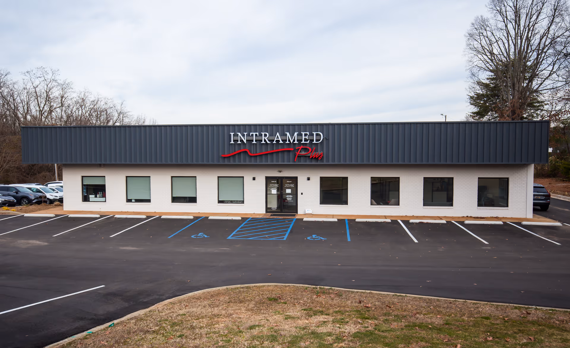 Front view of Intramed Plus facility with parking lot in foreground.