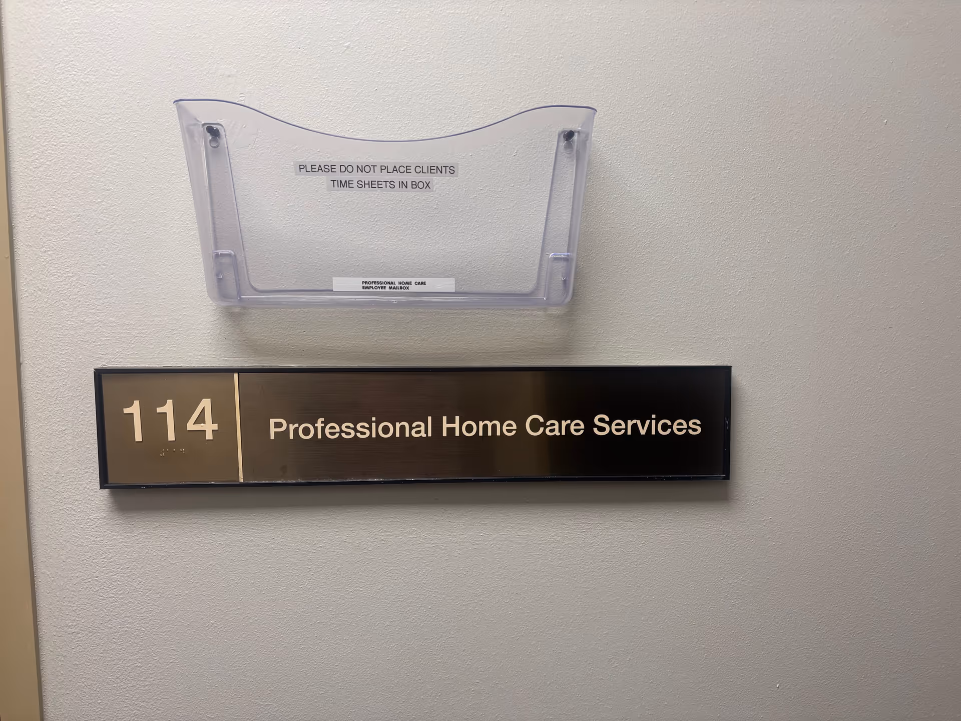 Wall-mounted sign reading '114 Professional Home Care Services' with a mail slot above.