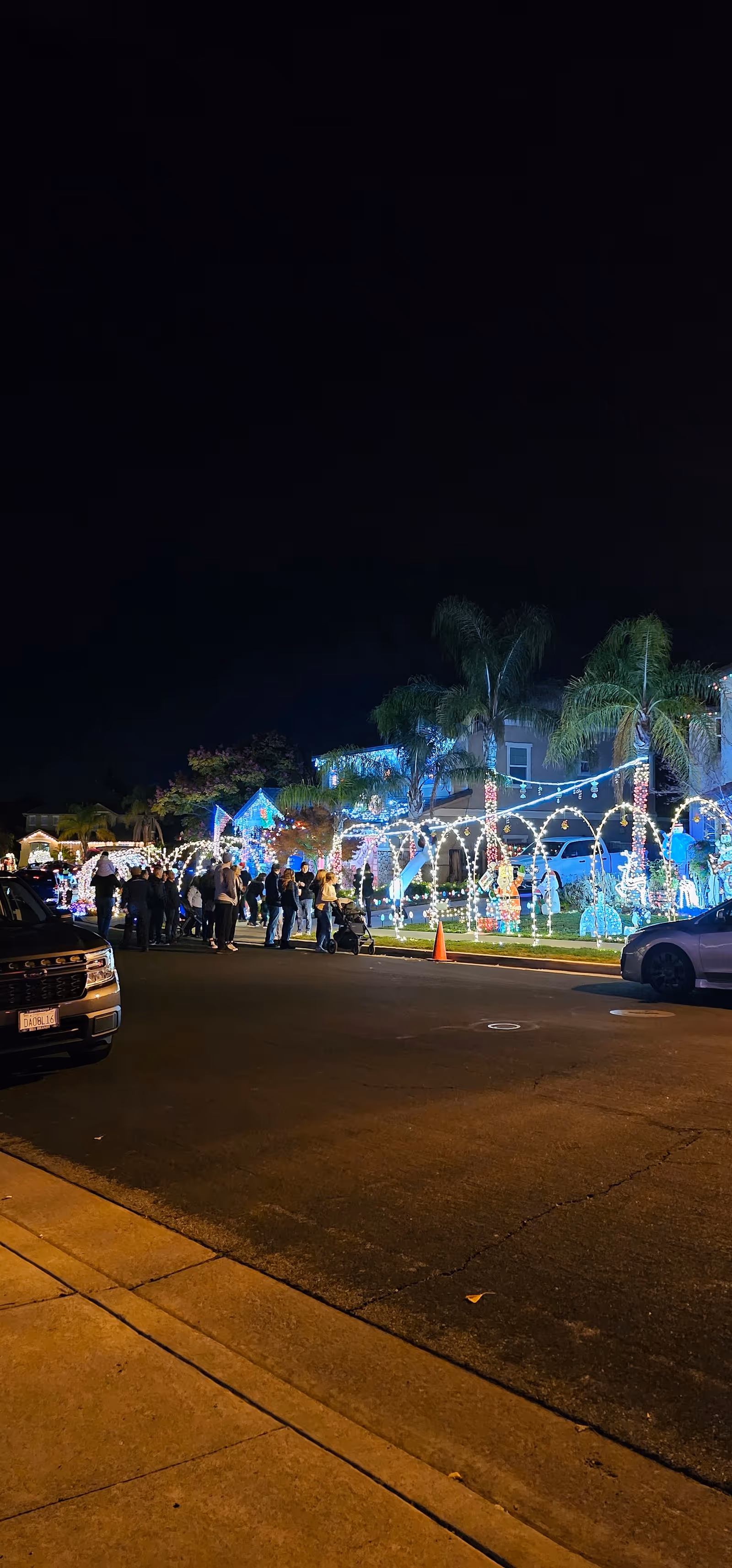 Night exterior of Angel Care Services of Northern California with festive lights and people outside.