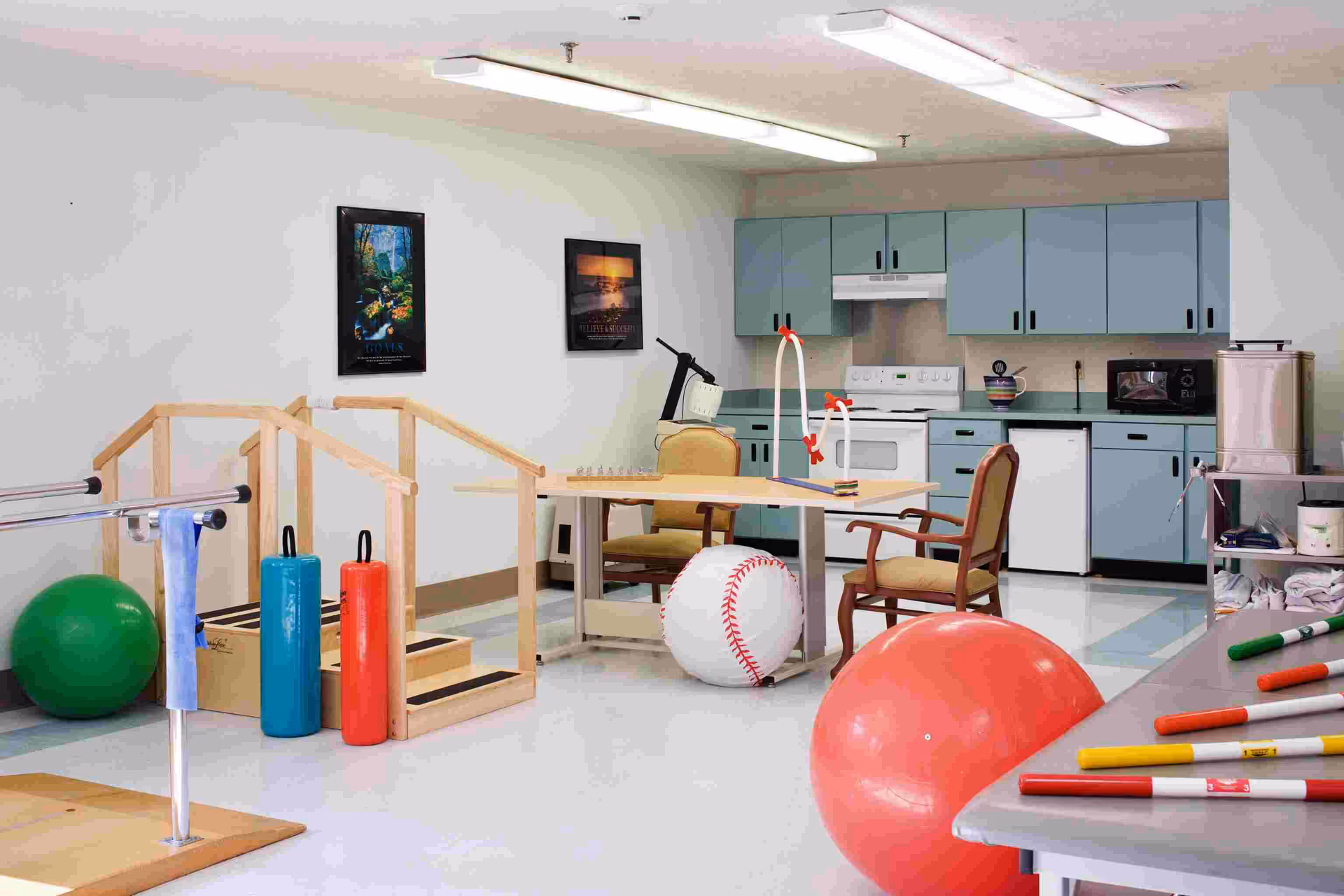 Interior therapy room at Raleigh Center with kitchenette, exercise gear, and seating.