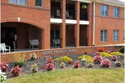 Brick senior living facility exterior with arches, columns, and a Saint Francis Home sign.