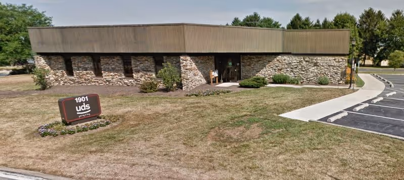Exterior view of United Disabilities Services building with parking lot and sign.