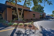 Exterior view of Bria of Belleville senior living facility with trees and parking.