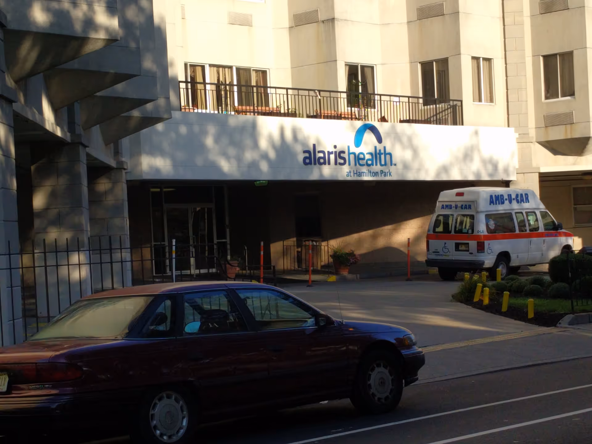Exterior view of Alaris Health at Hamilton Park entrance with an ambulance parked nearby.
