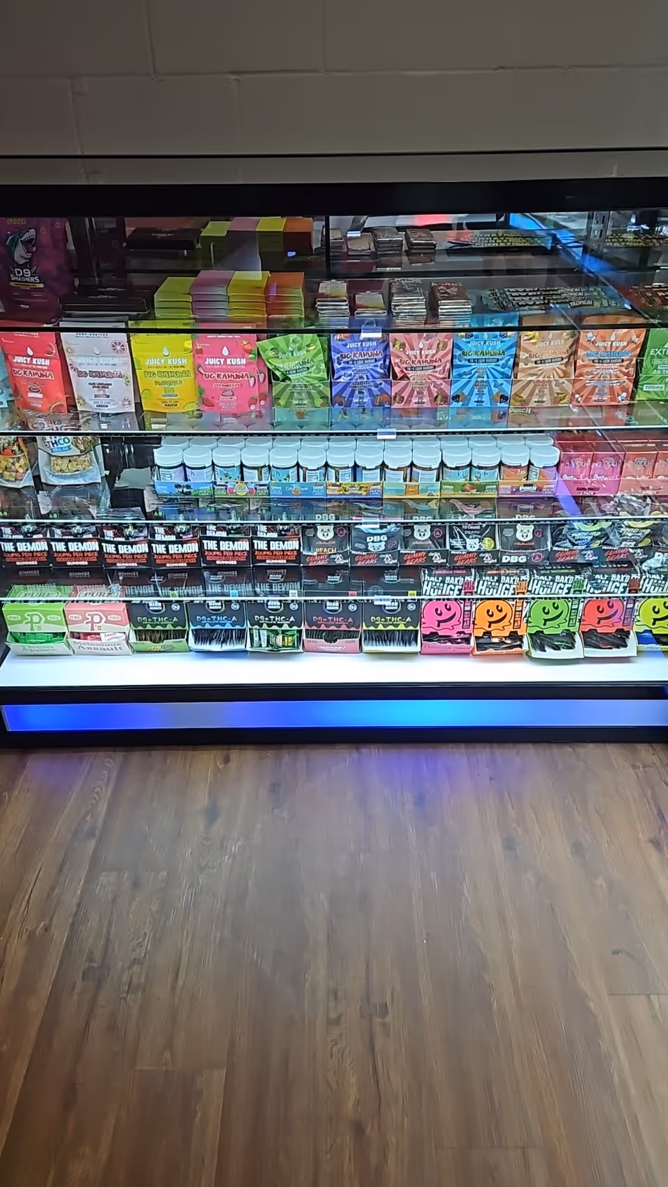 Colorful candy shelves behind glass in an interior facility setting.
