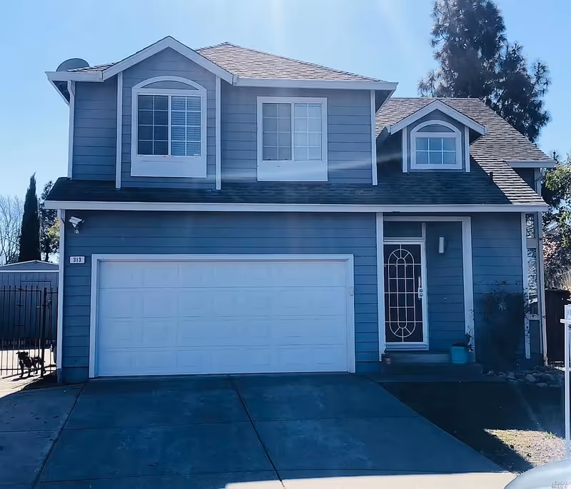 Blue two-story house with a front door and attached two-car garage.