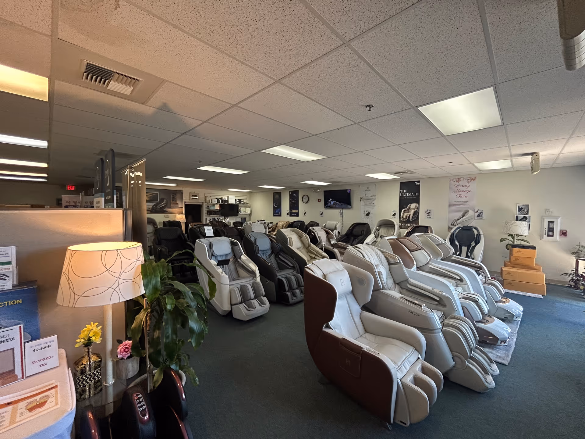 Row of massage chairs lined up in a spacious showroom inside an Ace Massage Chair facility.
