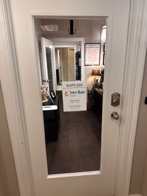 Doorway into a Notre Dame Hospice suite with signs and office furnishings.