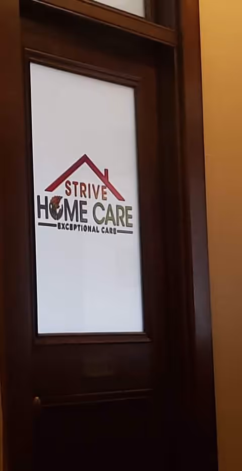 Wooden doorway features a frosted panel displaying the Strive Home Care logo.
