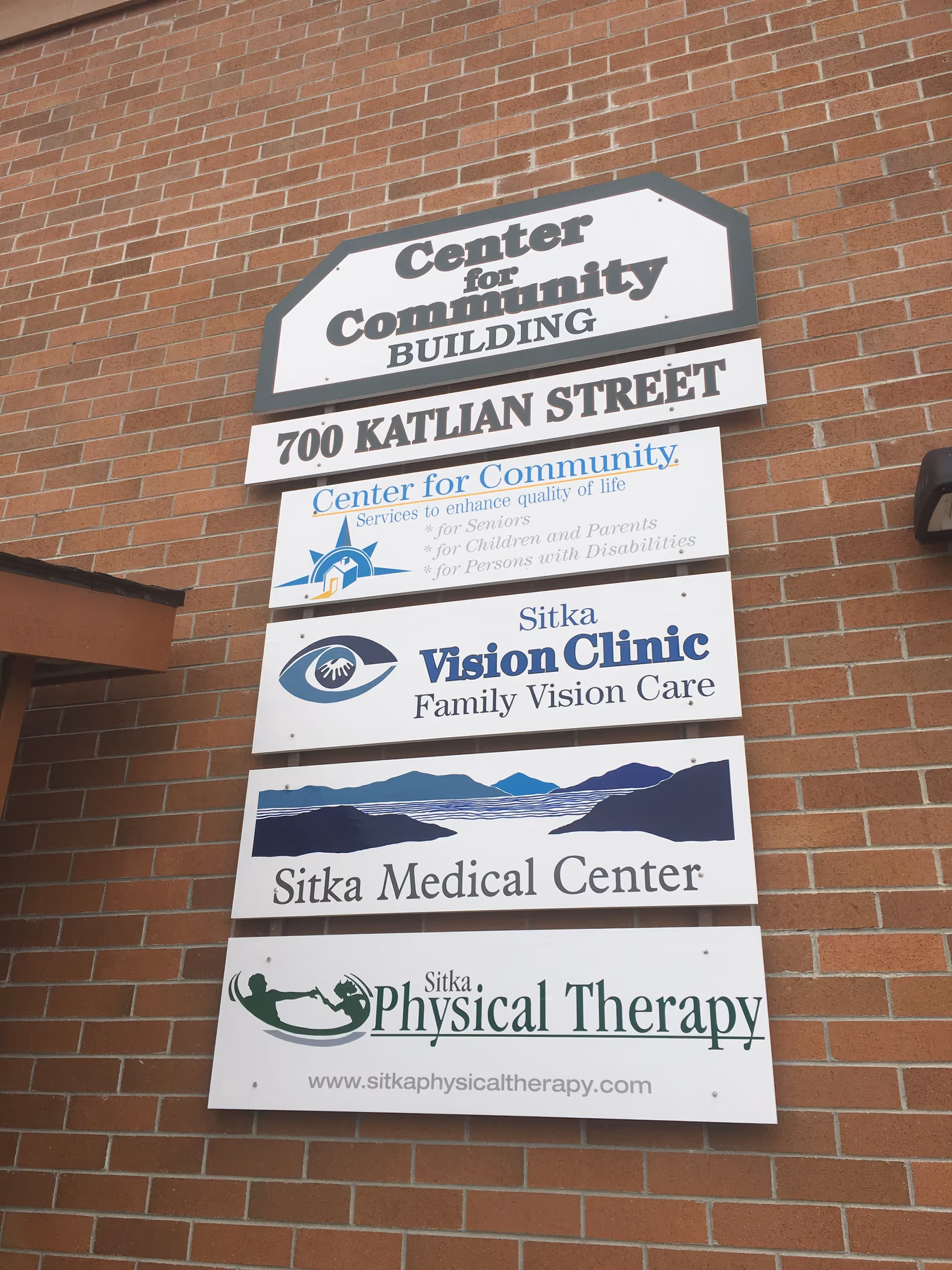 Brick building with stacked signs for Center for Community and medical services
