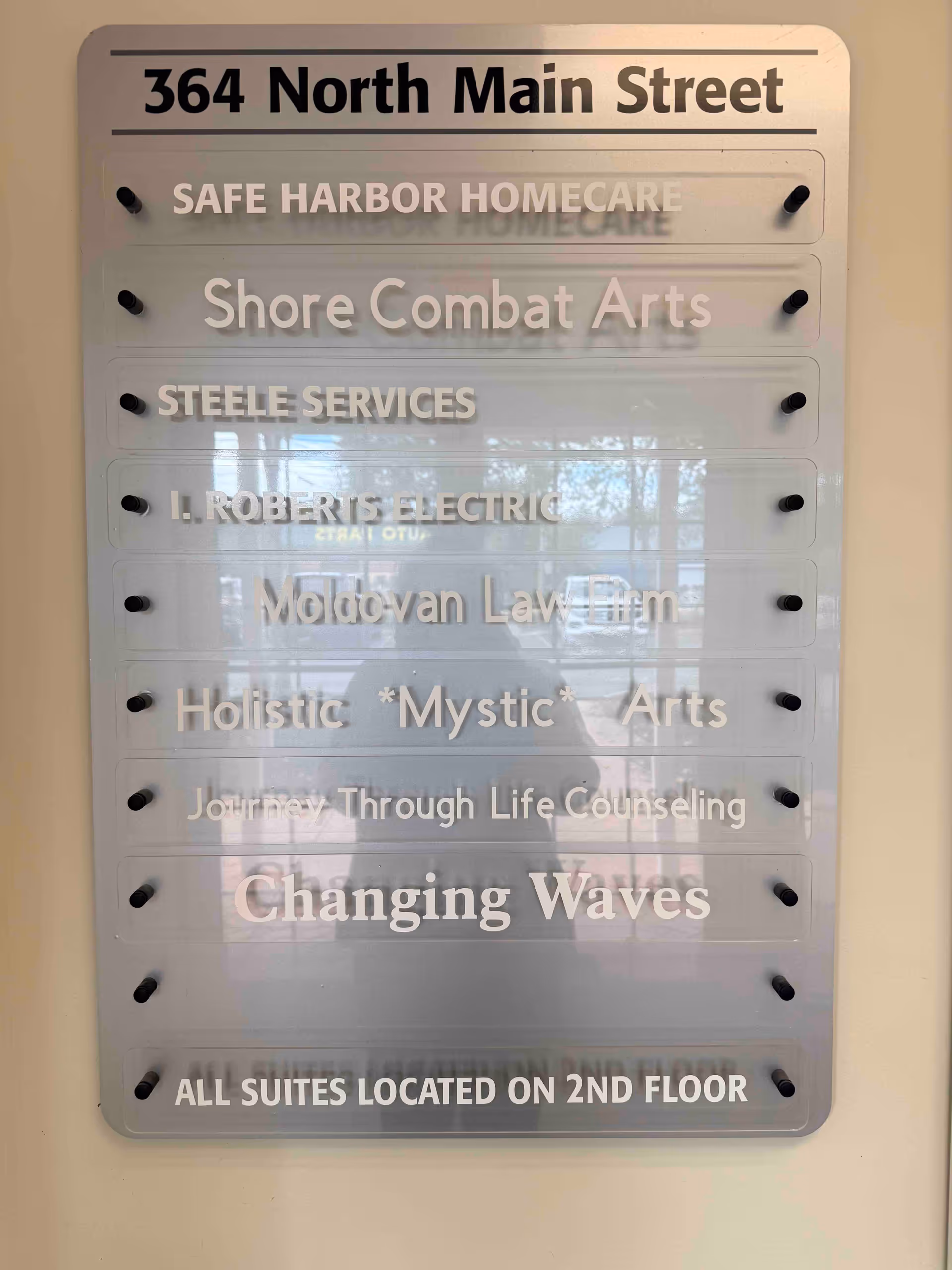 Indoor directory plaque listing multiple business names, including Safe Harbor Homecare, at 364 North Main Street.
