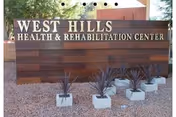 Front view of West Hills Health and Rehabilitation Center sign with planters.