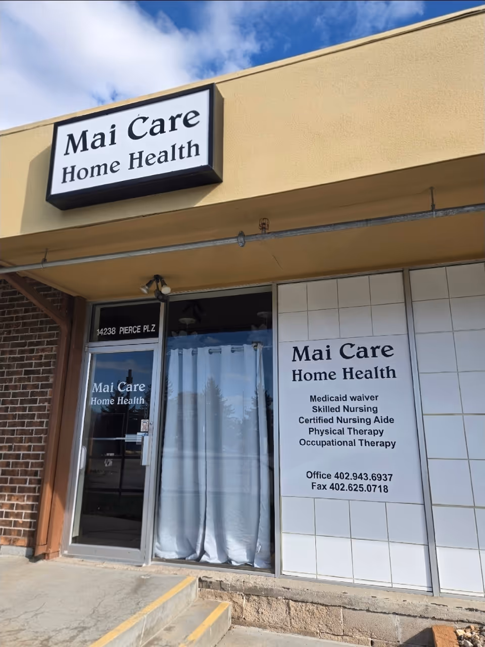 Front exterior of Mai Care Home Health with entrance and large signs.