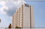 Exterior of a tall white high-rise building labeled Baptist Towers on a street.
