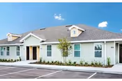 Exterior view of Quail Run Health Care Center with parking lot and landscaped entrance.