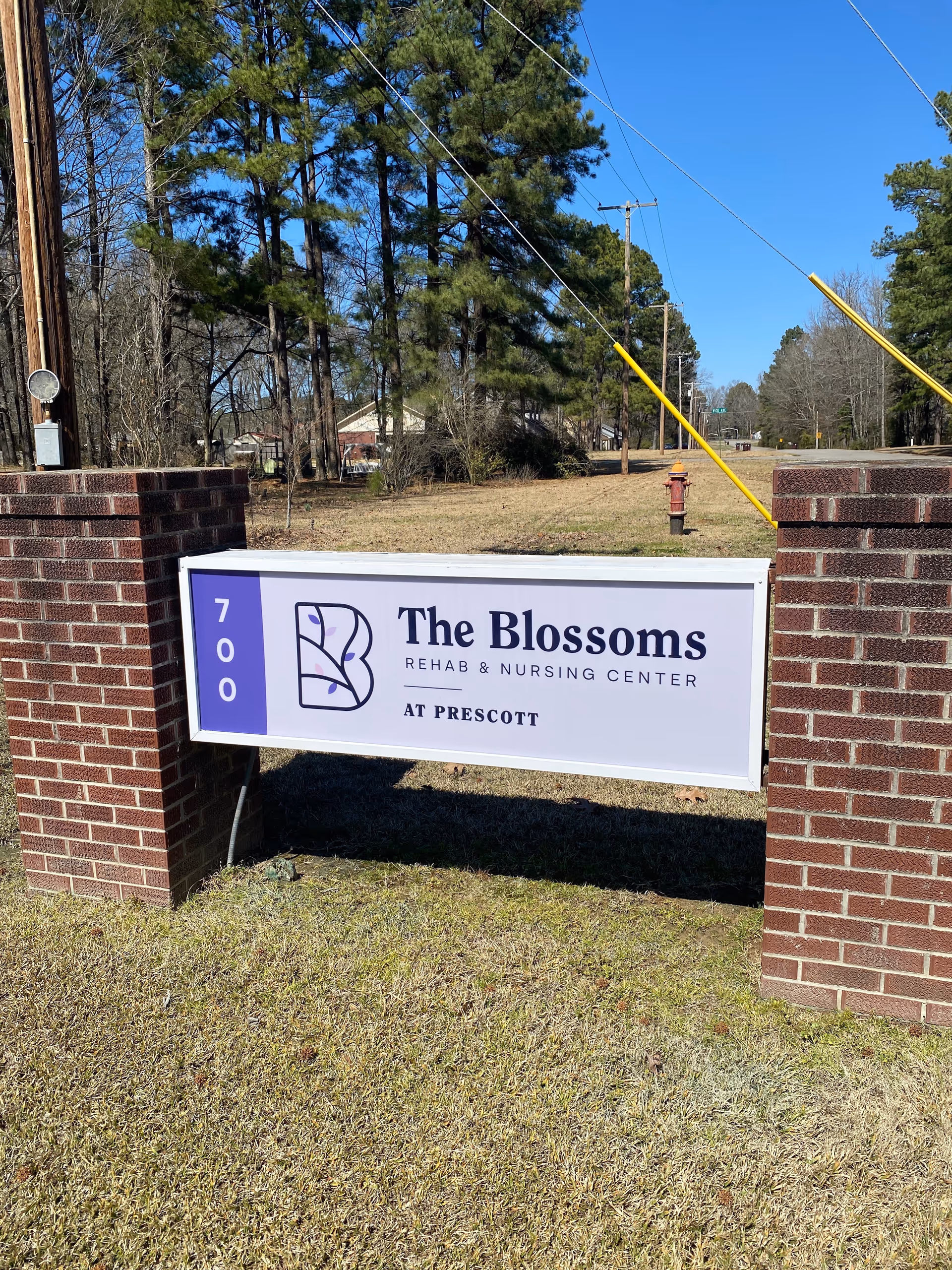 Outdoor brick entry with a sign reading The Blossoms Rehab & Nursing Center at Prescott.