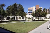 Exterior view of Boulder Creek Post Acute with a grassy courtyard, fountain, and trees.