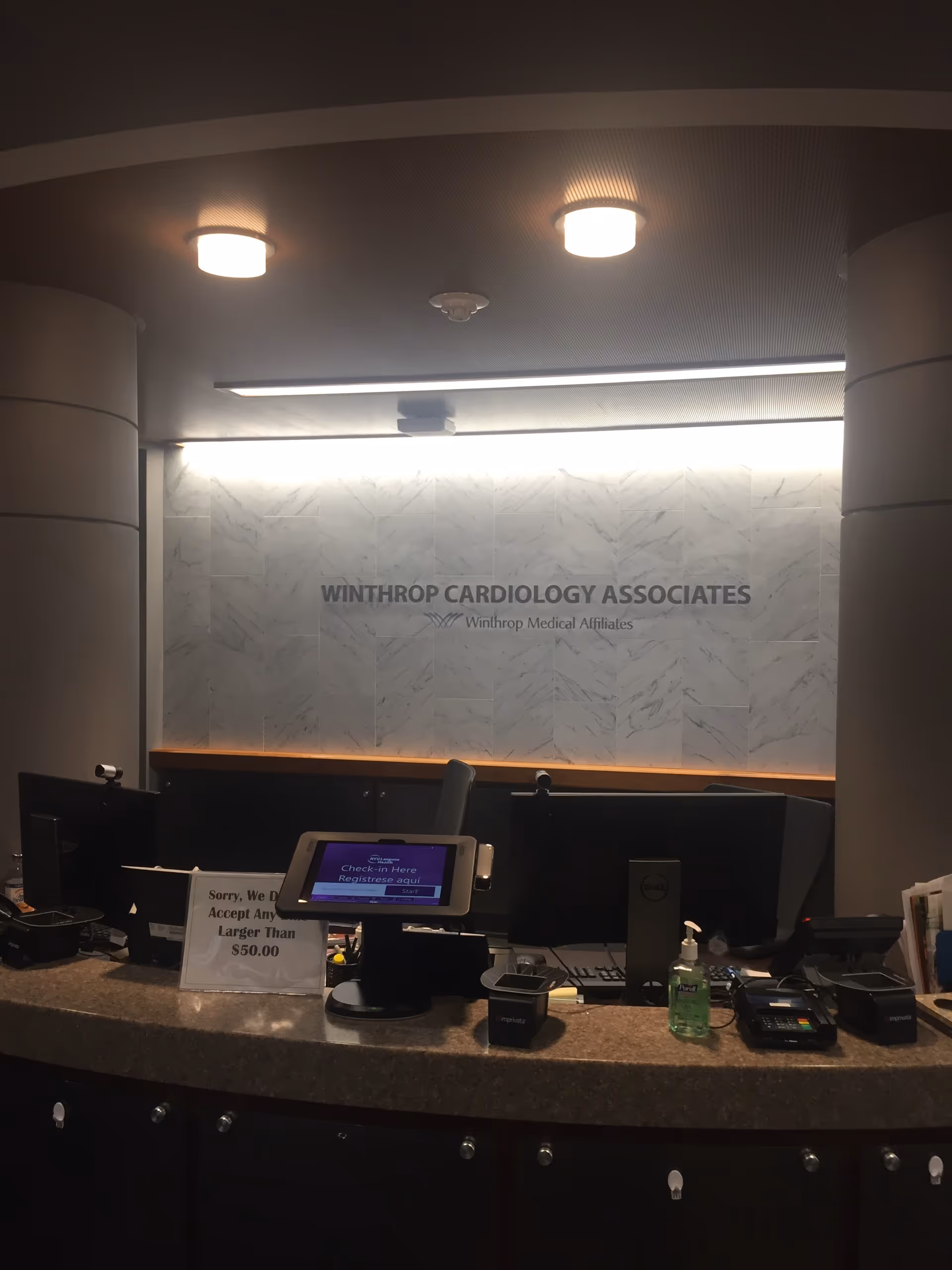 Reception area with marble wall, Winthrop Cardiology Associates sign, and check-in desk.