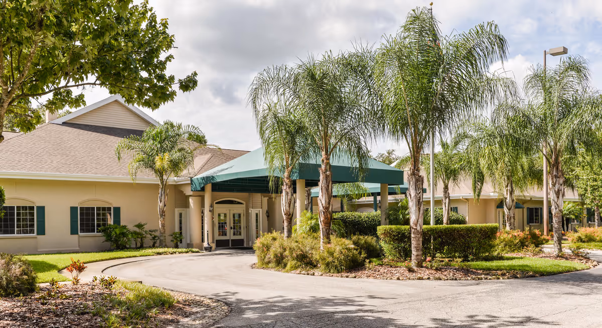 Exterior view of Northdale Rehabilitation Center entrance with a curved driveway and palm trees.
