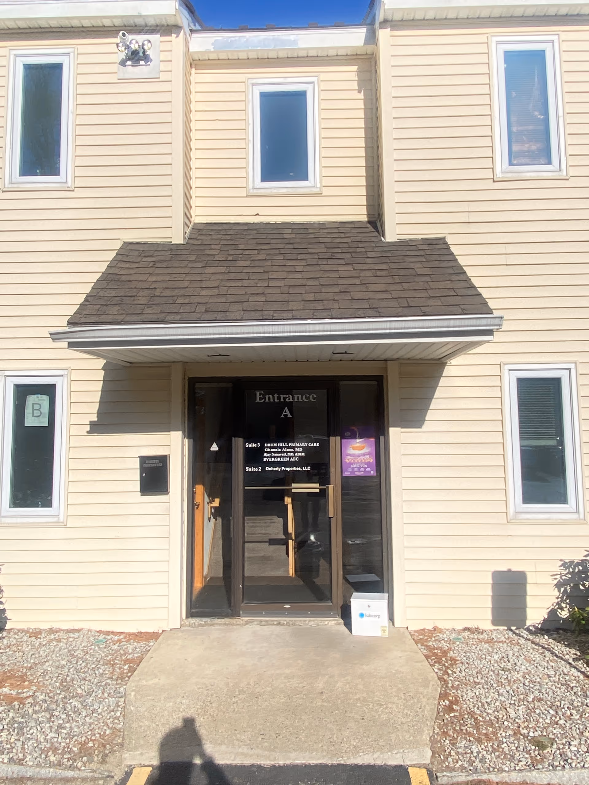 Front entrance of a beige building labeled Evergreen Adult Foster Care with a glass door