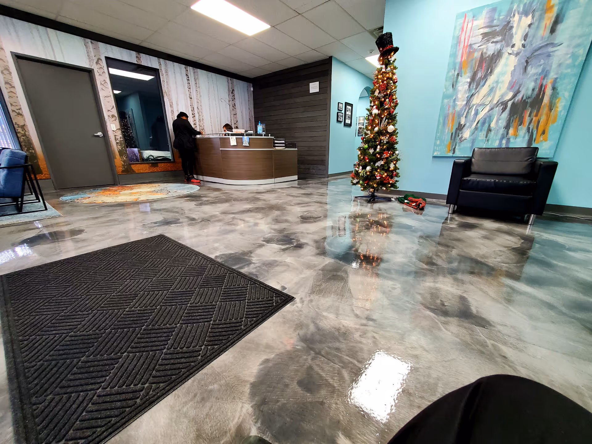 Reception area of a senior living facility with a decorated Christmas tree and seating.