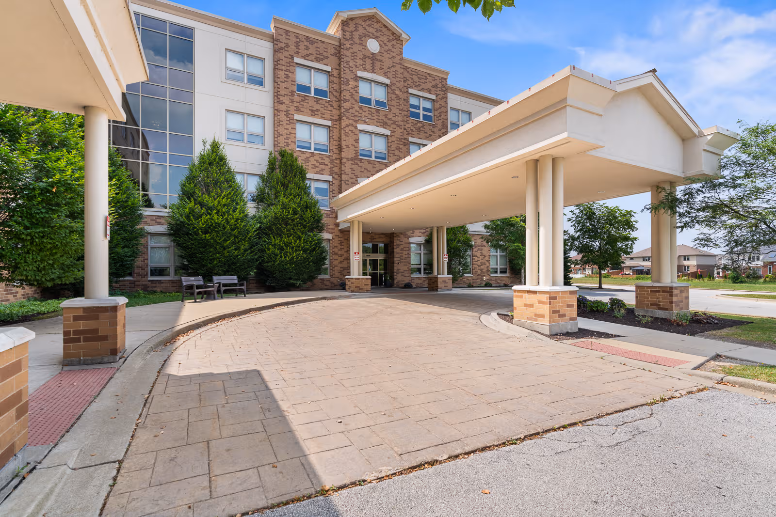 Front entrance of Elevate Care Country Club Hills, with brick building and covered drop-off area.